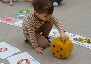 20. Chłopiec liczy oczka na kostce.