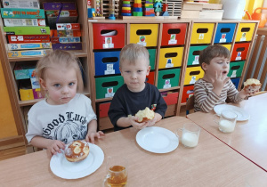 31. Dzieci jedzą pączki.