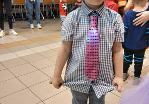 09. Chłopiec w okularach, kapeluszu i krawacie pozuje do zdjęcia.