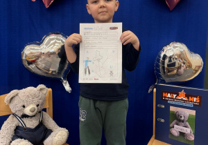 Chłopiec prezentuje swoją ulubioną historię przeczytaną Misiowi.