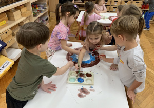 Dzieci podczas malowania farbami - praca w małych grupach.