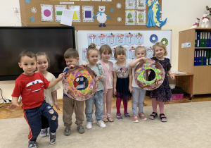 Dzieci prezentują kolorowe pączki.