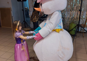 Dziewczynka tańczy z bałwankiem.