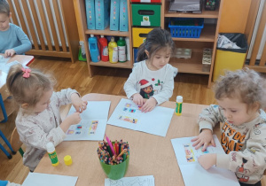 11 Dzieci wklejają postać Brawojki do książeczki