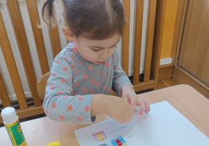 12 Dziewczynka wkleja Brawojkę do książeczki