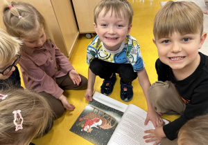 Kropelki oglądają książkę przyniesioną przez panią bibliotekarkę.