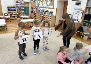 Dzieci układają wyraz za pomocą pani Pauliny.