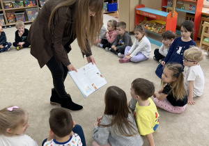 Pani pokazuje ilustracje z książki.