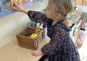 Dziewczynka zawiesza Brawojkę na plakacie.