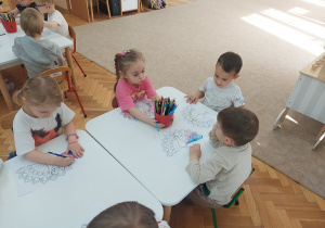 Przedszkolaki kolorują pawia.