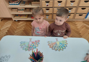 Dziewczynka i chłopiec ze swoimi pracami.