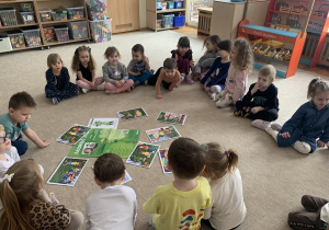 Dzieci oglądają ilustracje do opowiadania o Panu Zielonce.