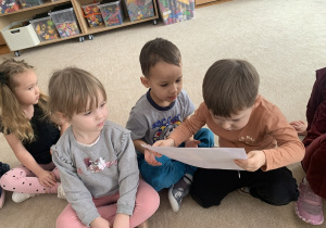 Chłopiec ogląda ilustracje do opowiadania.