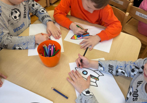 Dzieci kolorują rakiety według własnego pomysłu.