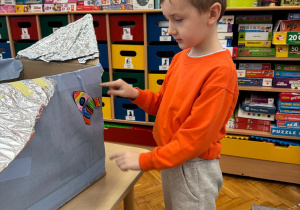 Chłopiec przygotowuje statek do startu, dodając swoją rakietę.