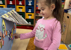 Dziewczynka tworzy kosmiczną dekorację, umieszczając swoją rakietę na statku.