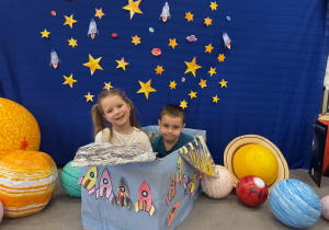 Dzieci wspólnie budują swoją wyobraźnię, bawiąc się w kosmonautów i ich statek z pudełka.