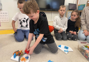 Chłopiec układa rybki na krze.