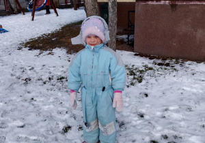 Dziewczynka ubrana w kombinezon zimowy.