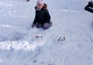 Dziewczynka stworzyła na śniegu stworki.
