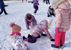 Dzieci bawią się na śniegu.