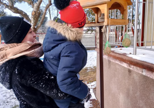 Chłopiec dokarmia ptaki.