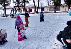 Dzieci bawią się na śniegu.