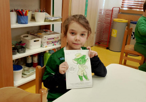 Dziewczynka pokazuje kolorowankę pana Zielonka.