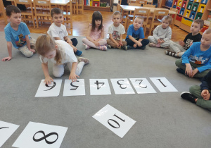 Dzieci układają kartki z cyframi.