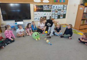 Dzieci siedzą w kole i słuchają informacji o kosmosie.