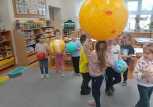 Dzieci trzymają w ręku planety.