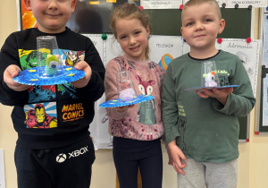 Dzieci pozują do wspólnego zdjęcia z ufoludkiem.