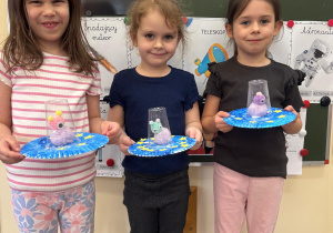 Dziewczynki pokazują prace wykonane przez siebie.