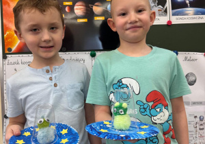 Chłopcy pozują ze swoimi pracami.