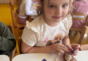 Dziewczynka zjada poczęstunek.