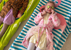 Dziewczynki leżą z ogórkami na oczach.