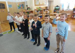 Chłopcy trzymają w ręku medale dla dziewczynek.