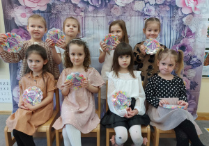 Dziewczynki pozują do wspólnego zdjęcia i trzymają w ręku upominki, które otrzymay.