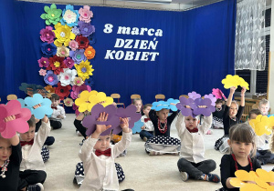 Taniec na siedząco z papierowymi kwiatami.