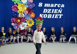 Chłopiec w roli tulipanka spaceruje po sali.