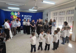 Chłopcy z grupy Kropelek wręczają wszystkim paniom prezenty.