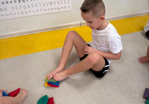 Chłopiec układa z woreczków wieżę.