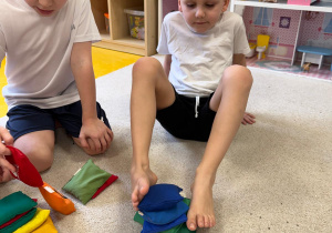 Chłopiec układa z woreczków wieżę.