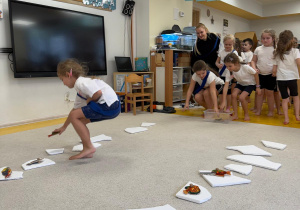 Dziewczynka zabiera rybkę z kry lodu.