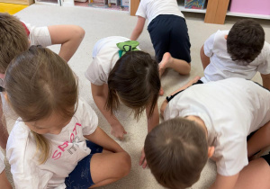 Dzieci zrzucają worki gimnastyczne do koła.