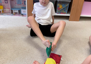 Chłopcy układają z woreczków wieżę za pomocą stóp.