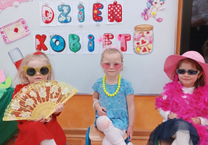 26 Dziewczynki siedzą na krzesłach i pozują do zdjęcia