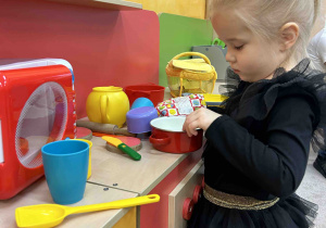 Dziewczynka bawi się w kuchni.