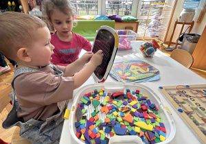 Chłopczyk bawi się przy stoliczku.