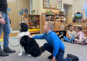 Chłopiec głaszcze psa.
